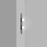 two bulb wall sconce on a grey wall with oval textured backplate
