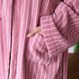 Close-up of a pink robe with white stripes worn by a person.