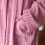 Close-up of a pink robe with white stripes worn by a person.