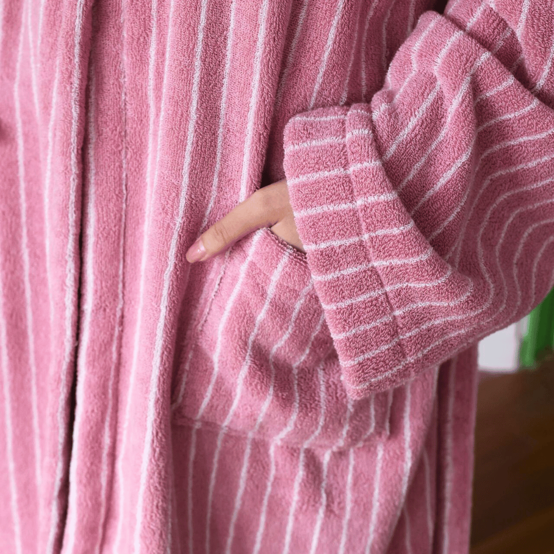 Close-up of a pink robe with white stripes worn by a person.