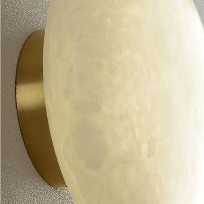 Close-up of a gold circular object on a textured beige background