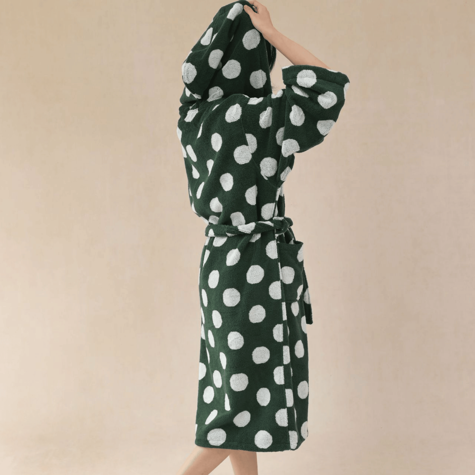 Green dress with white polka dots on a beige background