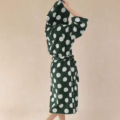 Green dress with white polka dots on a beige background