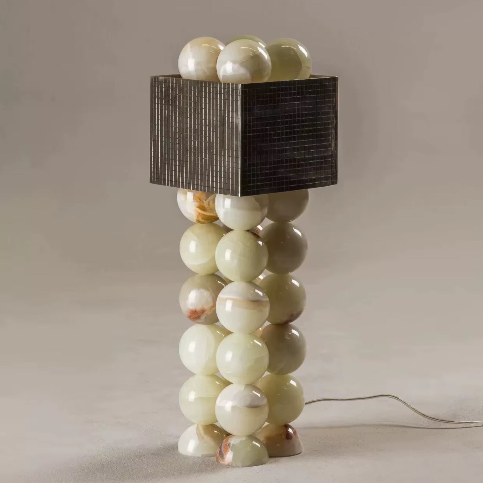 Decorative lamp with spherical base and rectangular shade on a neutral background