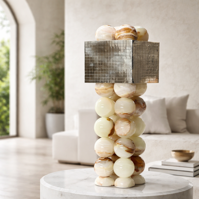 Decorative lamp with stacked spherical design on a table in a living room.