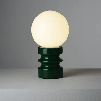 Table lamp with a green base and white bulb on a gray background