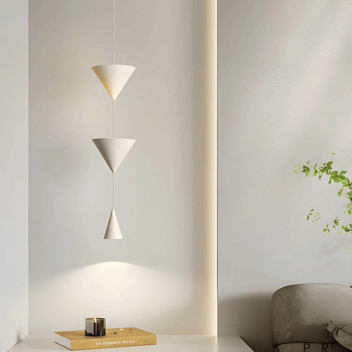 Modern pendant light fixture in a minimalistic room setting with a plant and books.