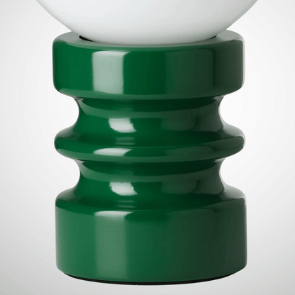 Close-up of a green lamp base with a white lampshade on a light gray background