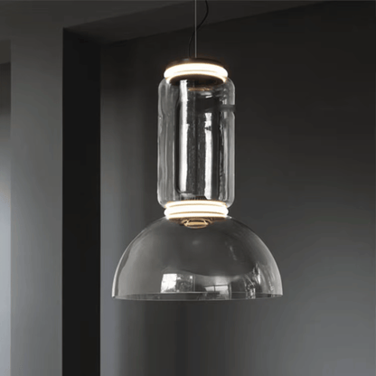 Modern pendant light with clear glass shade against a dark background