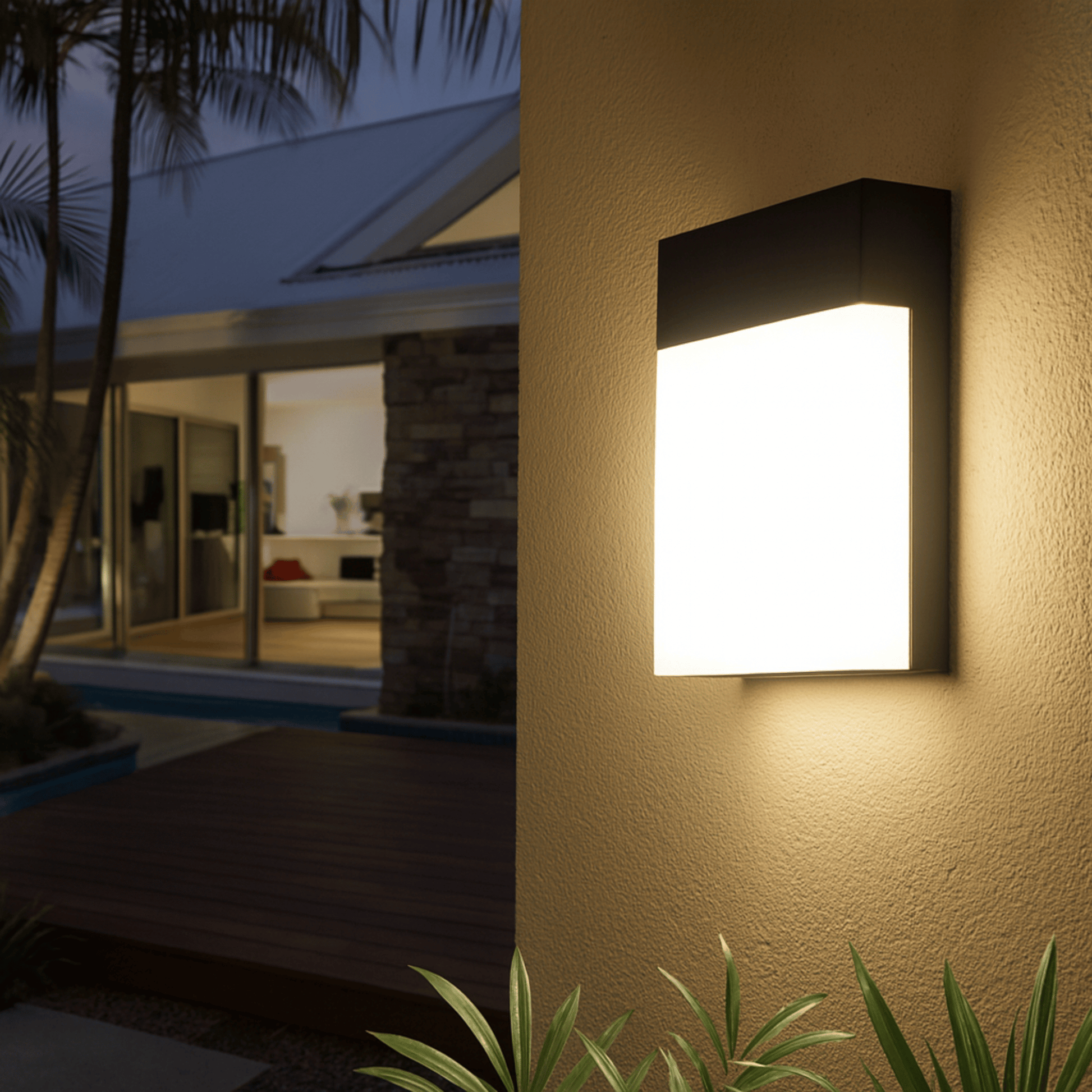 Modern outdoor wall light fixture on a house exterior at night.