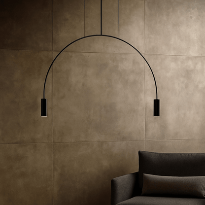 Modern black pendant light against a brown tiled wall with a dark sofa.