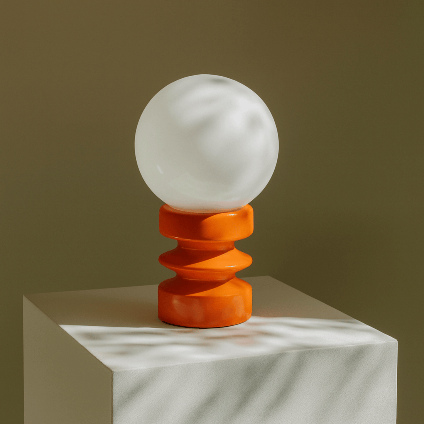 Decorative lamp with a white globe and orange base on a neutral background