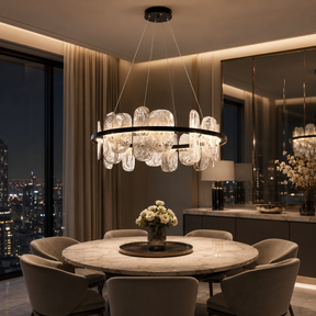 Modern dining room with a large chandelier, round table, and chairs.