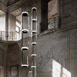 Modern chandelier hanging in an elegant interior setting with architectural details.