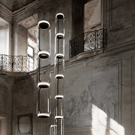 Modern chandelier hanging in an elegant interior setting with architectural details.