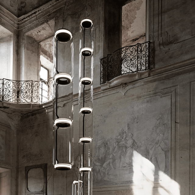 Modern chandelier hanging in an elegant interior setting with architectural details.