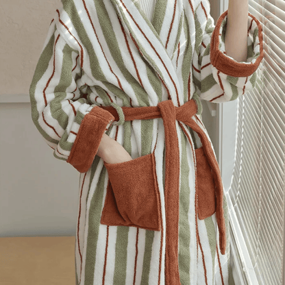 Striped robe with brown accents worn by a person, standing in a neutral indoor setting.
