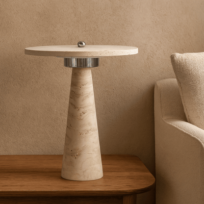 Beige side table with marble-like finish next to a beige armchair against a beige wall.