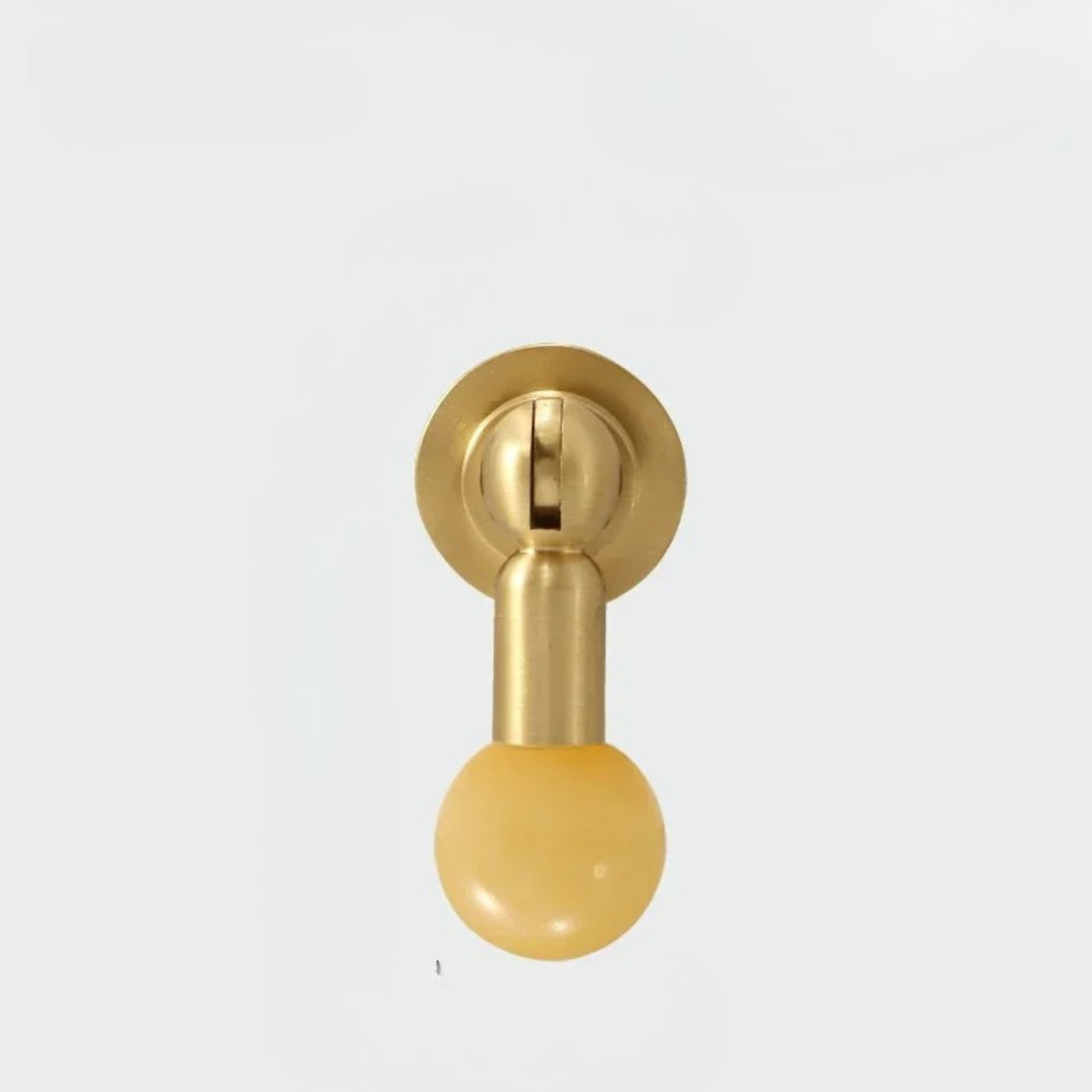 Single brass knob with matte yellow gemstone sphere handle on clean white background.