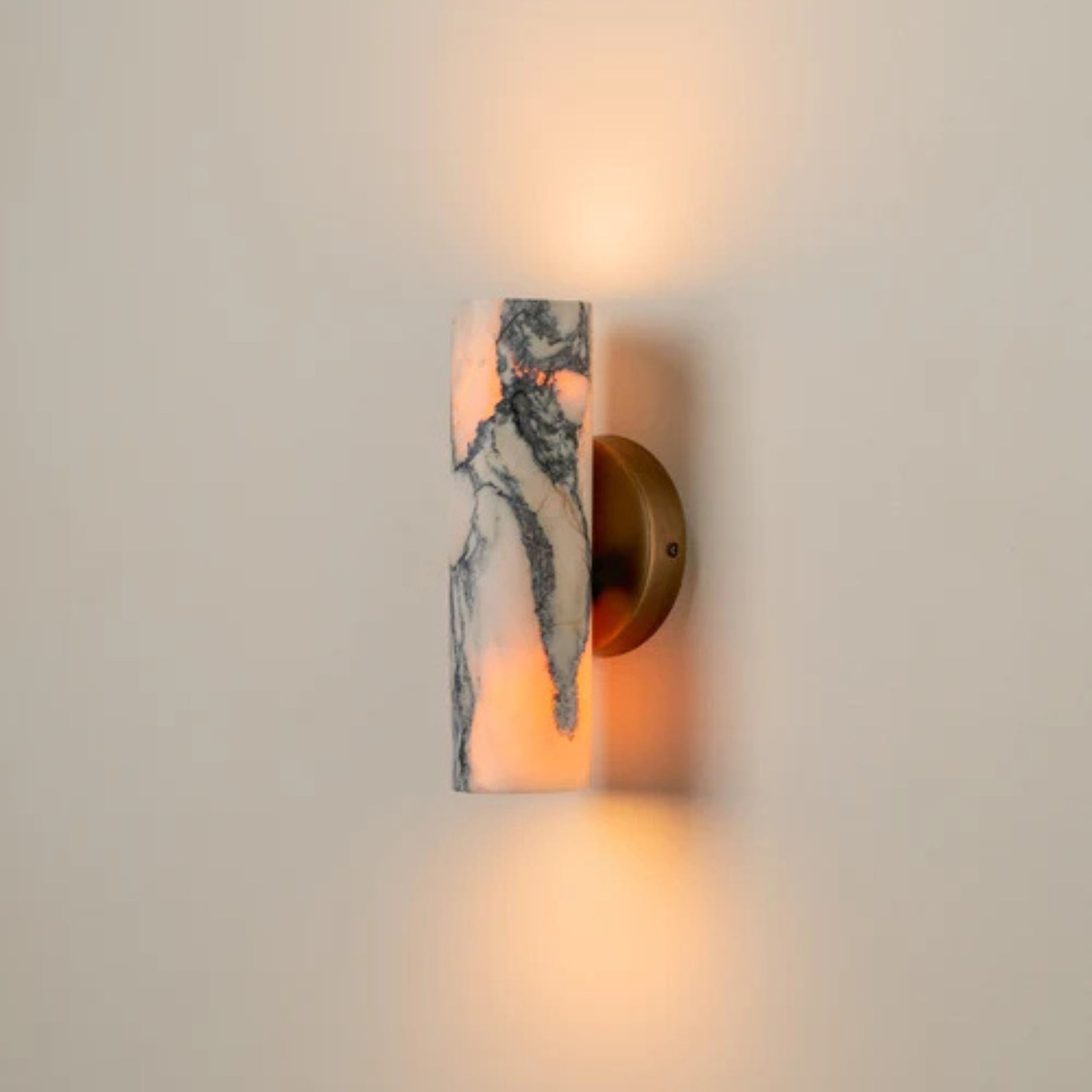Contemporary marble wall light with warm illumination installed on an interior wall.