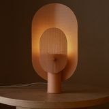 Modern table lamp with perforated design on a dark background