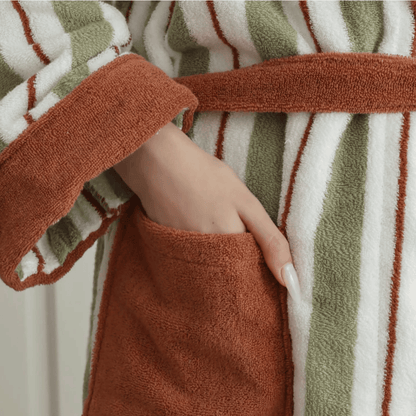Close-up of a person wearing a striped robe with brown, green, and white colors.