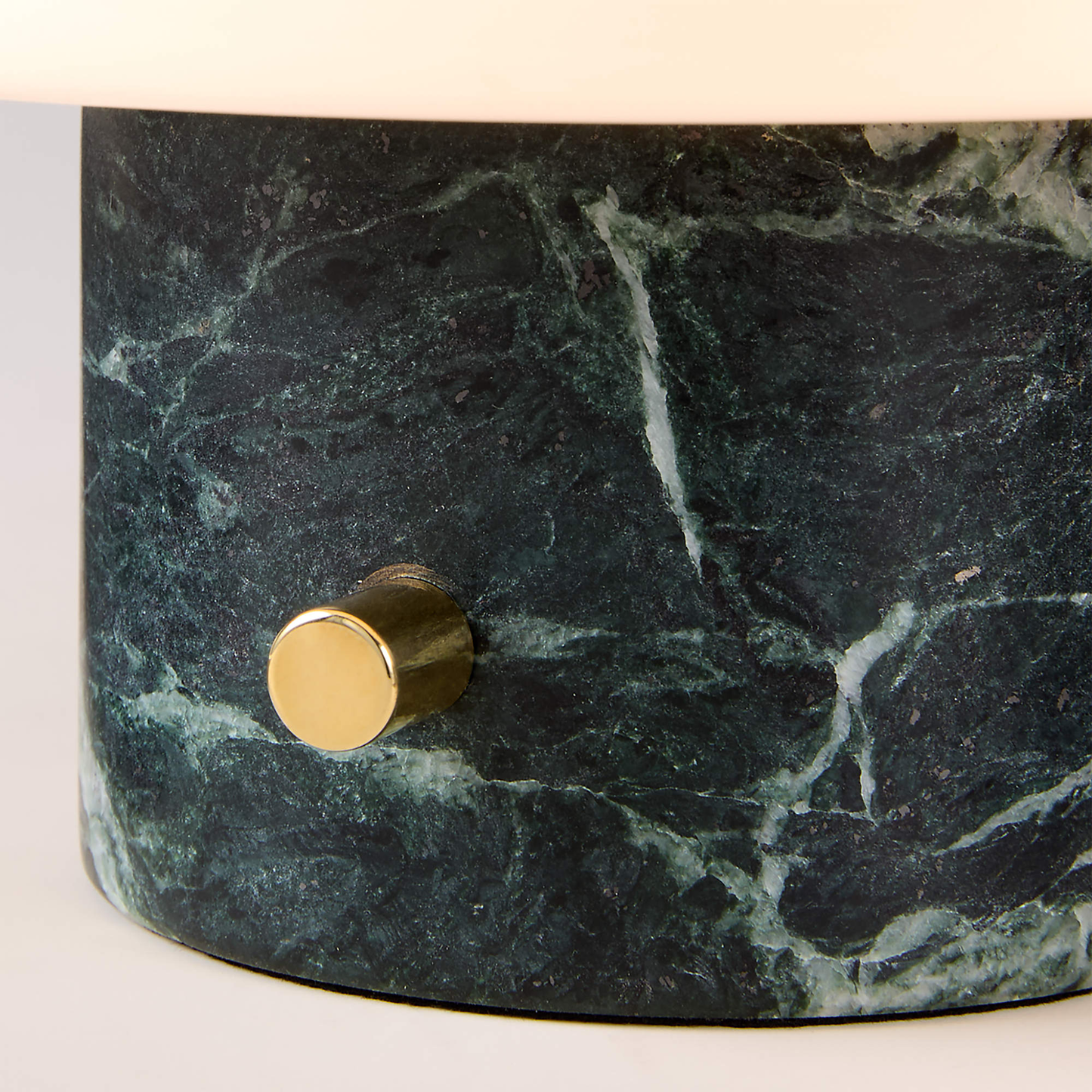 Marble cylindrical container with gold knob on a white background