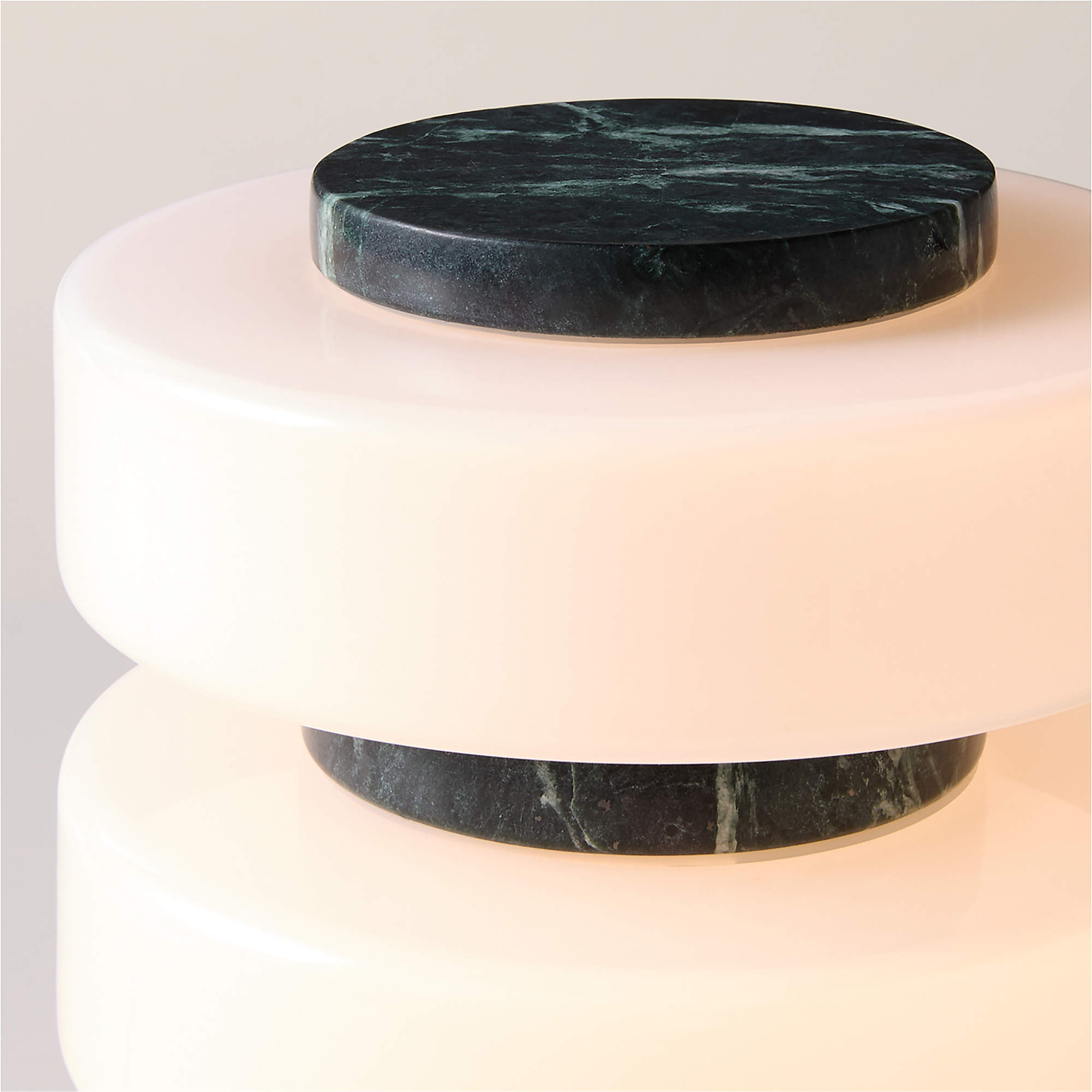 Two cylindrical marble tables with a dark green marble top and light pink base.