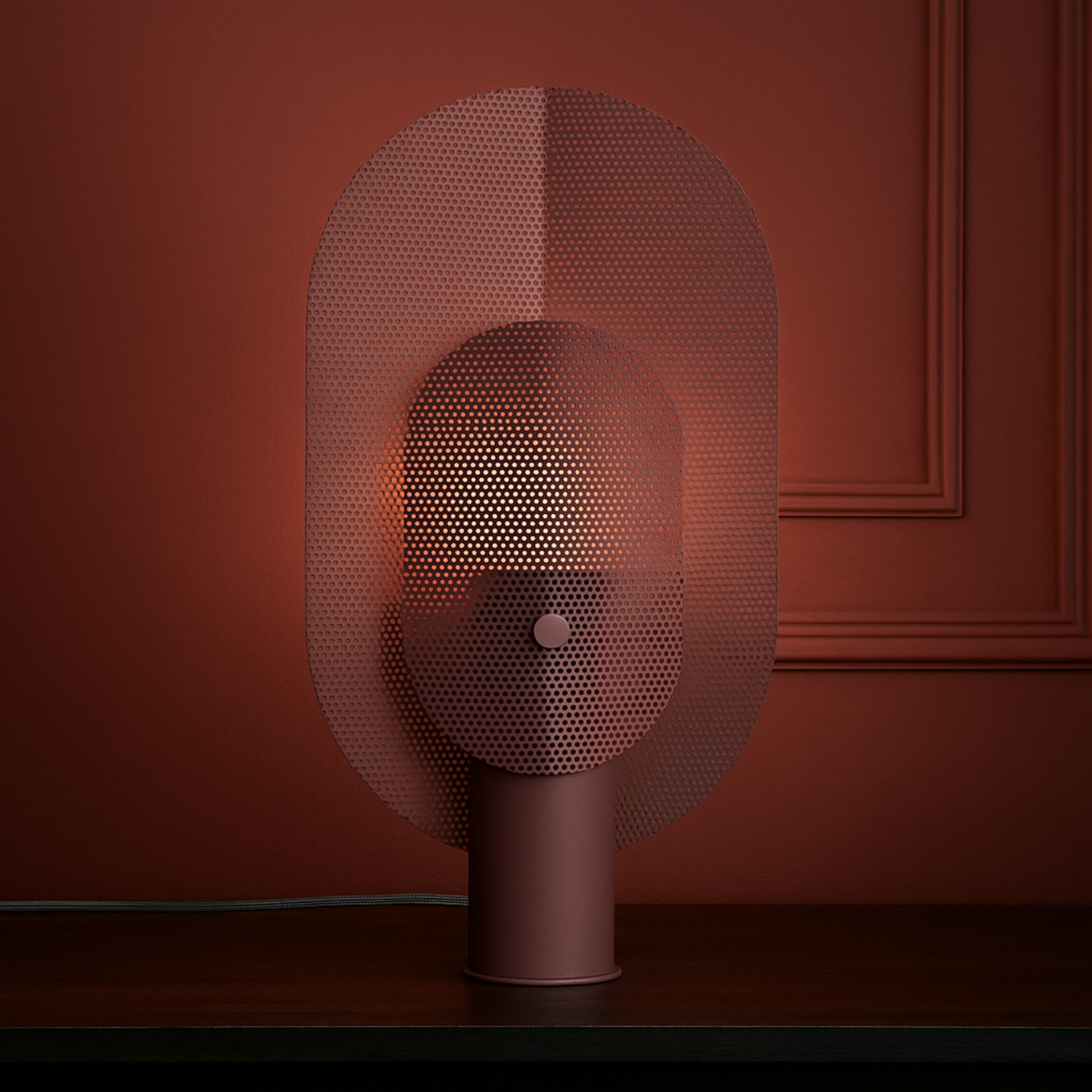 Decorative lamp with a mesh shade against a red wall