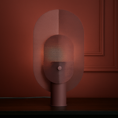 Decorative lamp with a mesh shade against a red wall