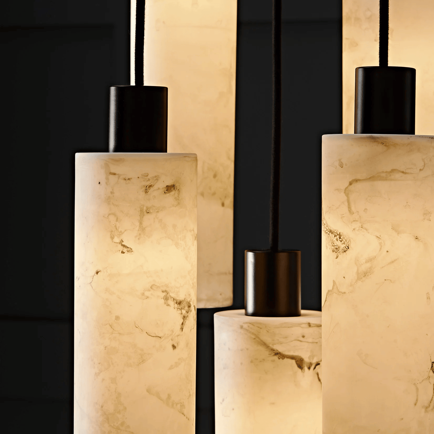 Decorative lamps with marble-like bases and black canisters on a dark background