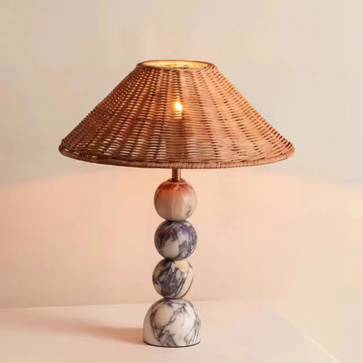 Table lamp with wicker shade and marble base on a light background