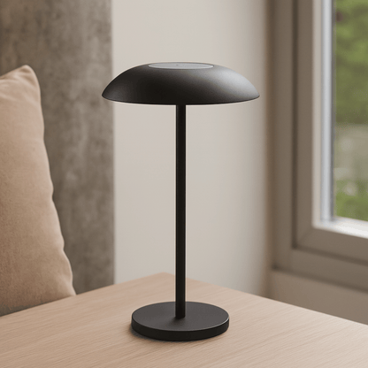 Black table lamp on a wooden surface with a neutral background