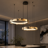 Modern pendant lights hanging above a dining table in a dimly lit room.