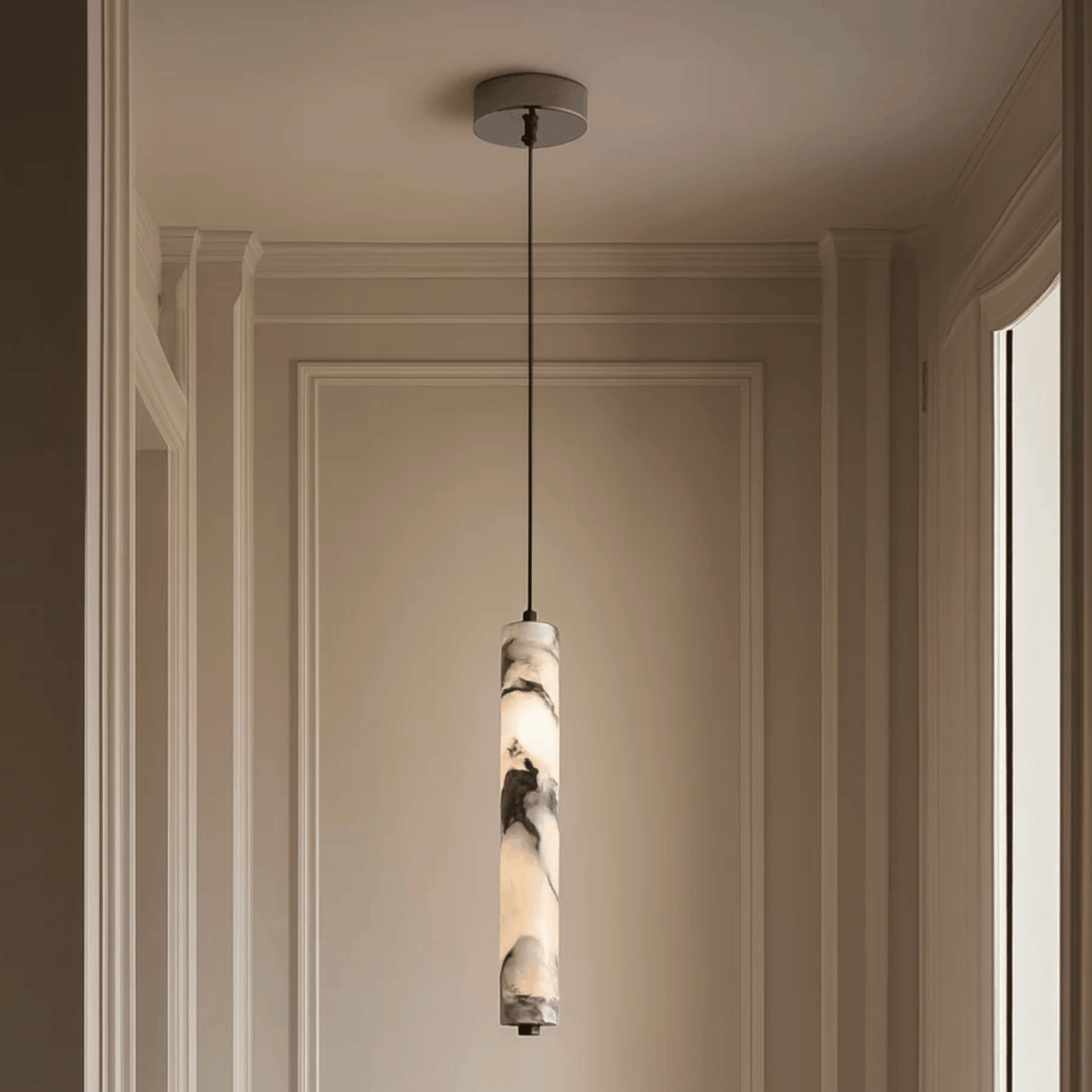 Pendant light fixture hanging from the ceiling in a room with beige walls.