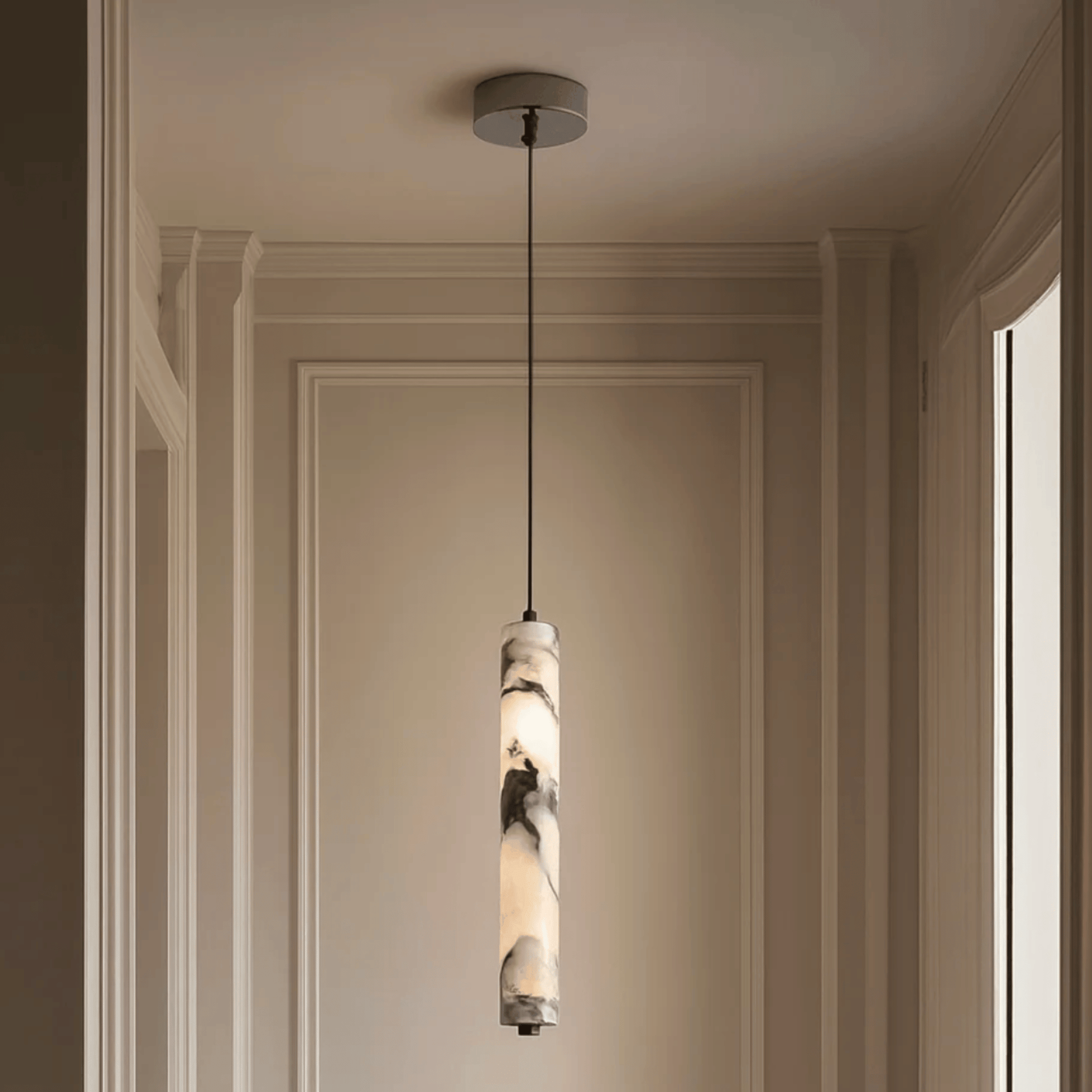 Pendant light fixture hanging from the ceiling in a room with beige walls.