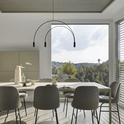 Modern dining room with a long table and chairs, featuring a stylish pendant light.
