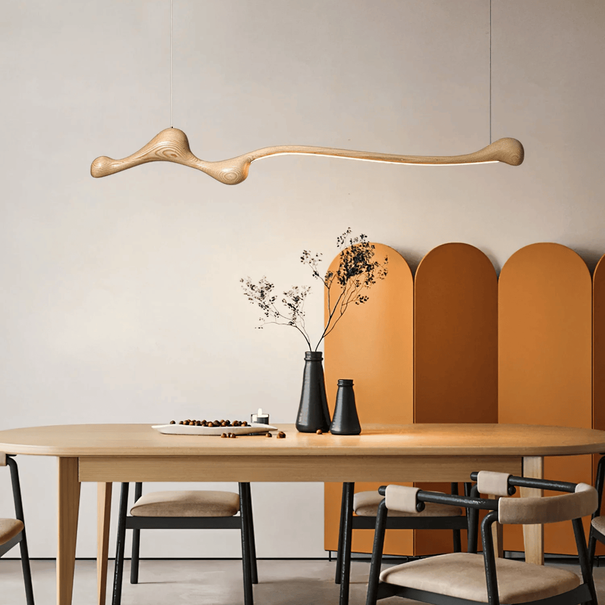 Dining area with a wooden table, chairs, and decorative elements against a neutral wall.