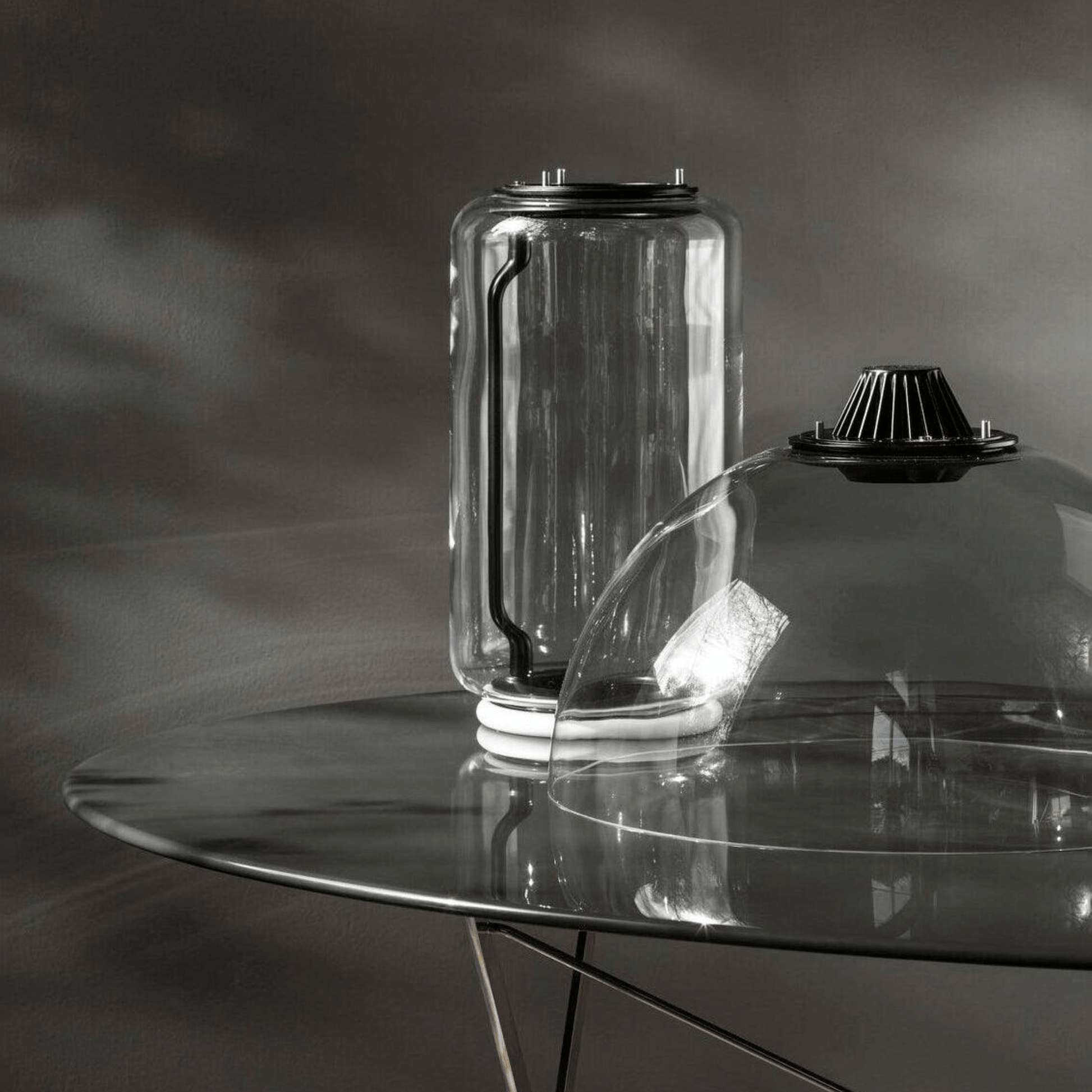 Clear glass container on a reflective surface with a dark background