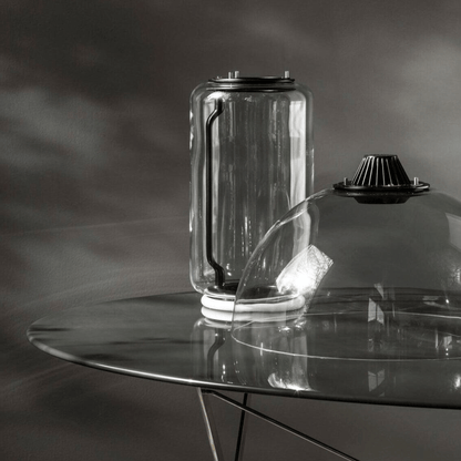 Clear glass container on a reflective surface with a dark background