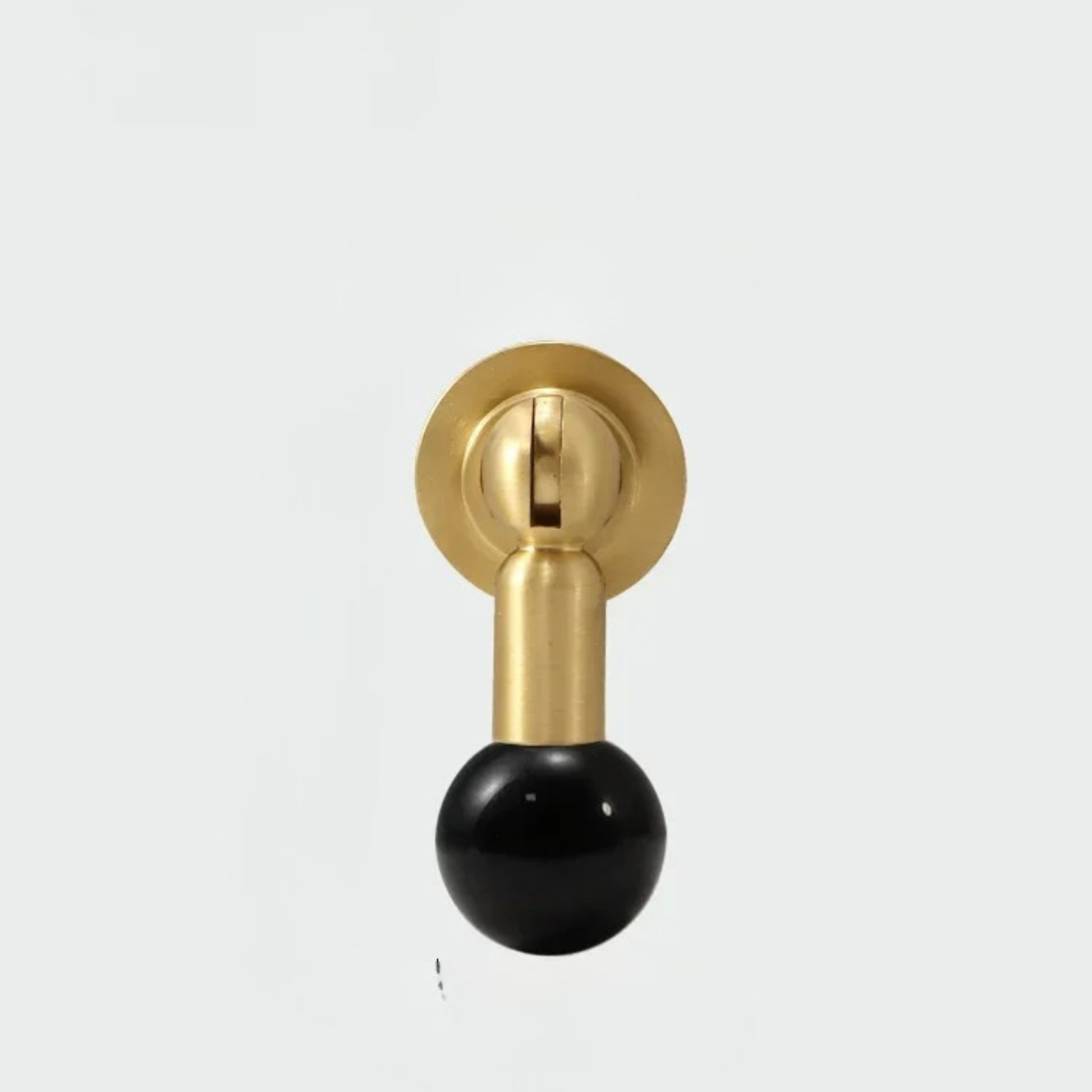 Brass cabinet knob with glossy black gemstone sphere handle on white background.