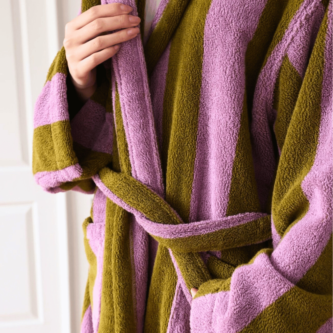 Close-up of a person wearing a green and pink striped robe.