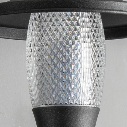 Close-up of modern outdoor light fixture showing detailed glass pattern and matte black base.