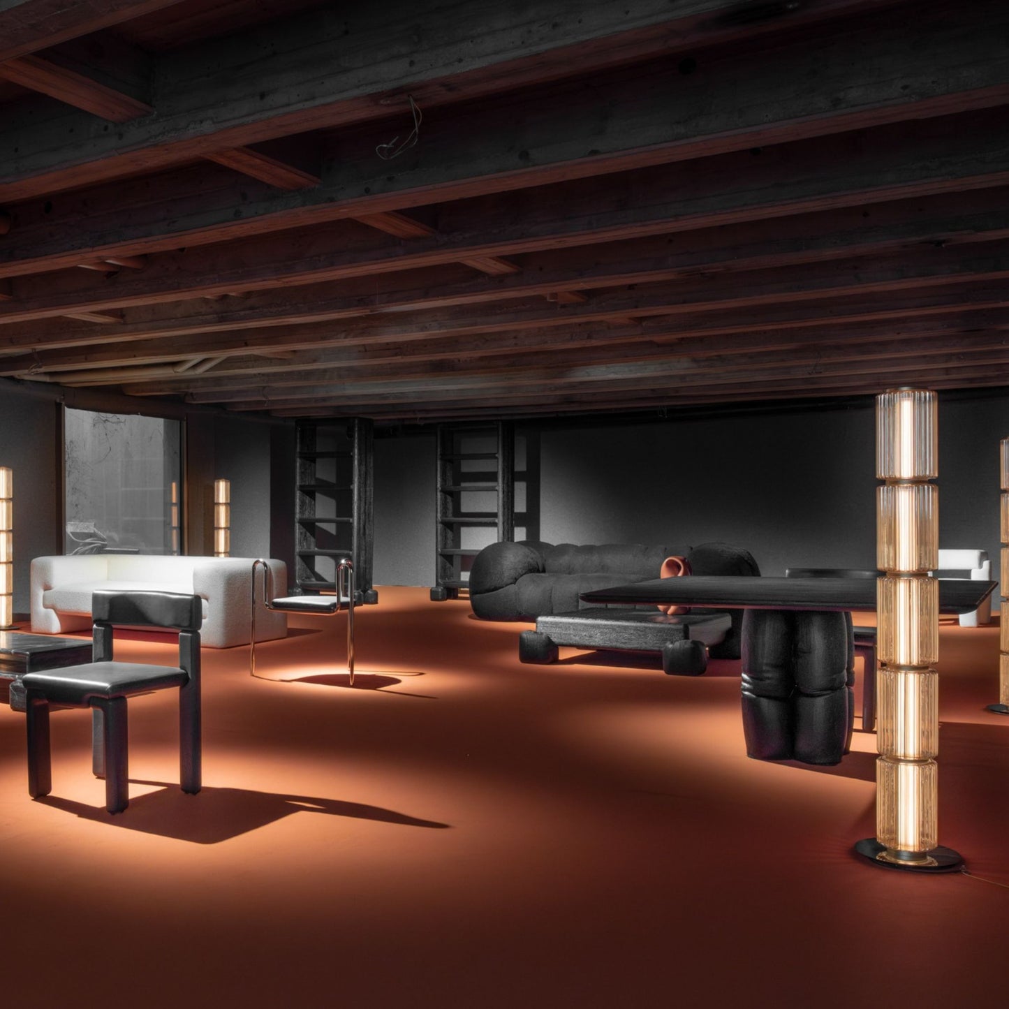 Group of tall ribbed-glass floor lamps creating soft ambient light in a dark, modern room with an orange floor.