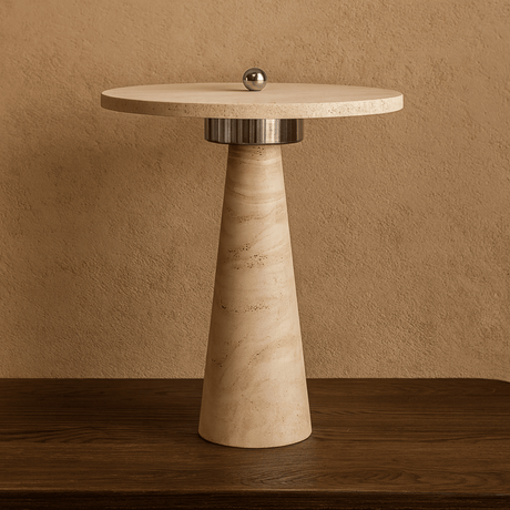 Round side table with marble-like finish and metallic base against a beige wall.