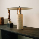 Modern wooden console table with a bamboo and metal lamp next to small decorative items
