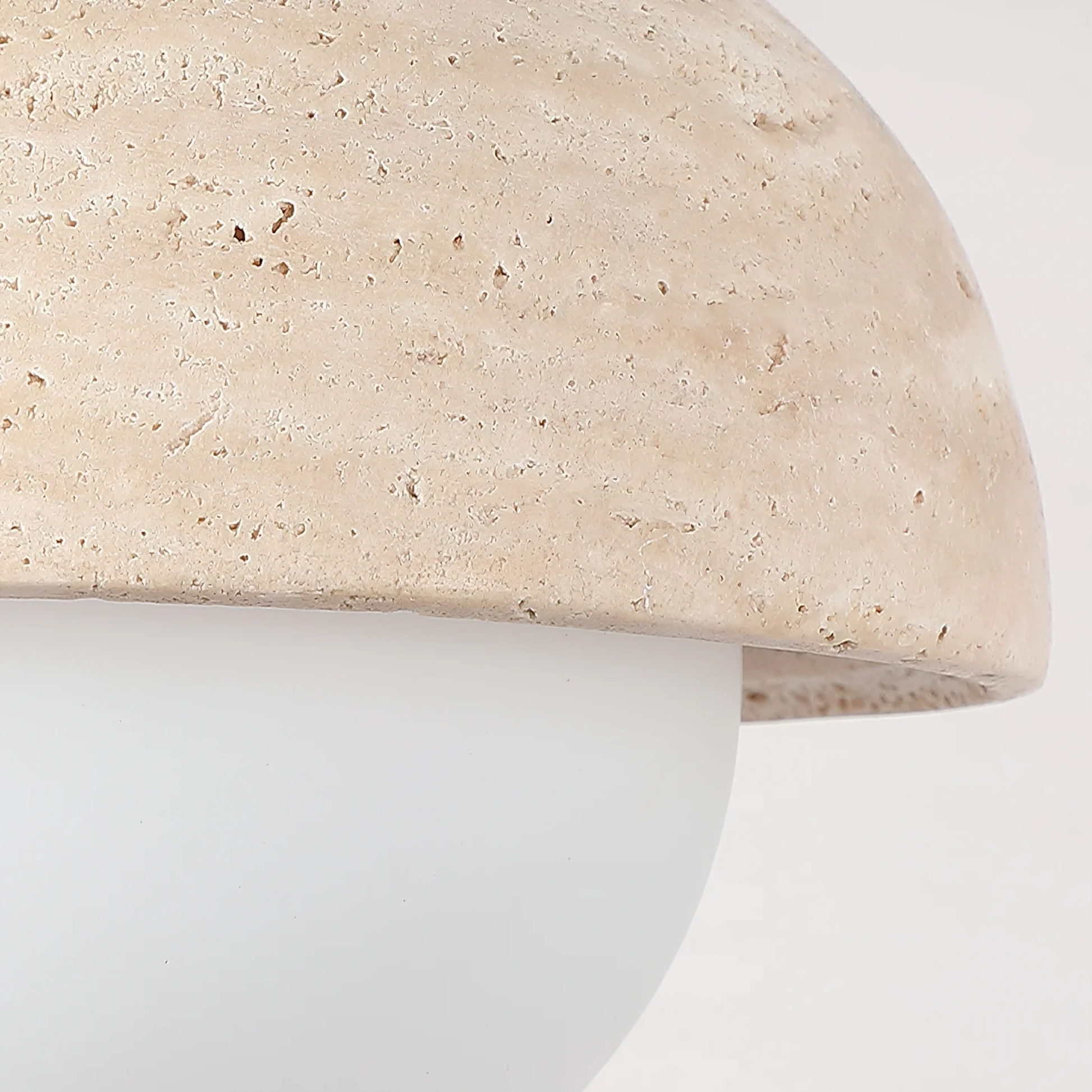 Close-up of a beige stone surface with a white base