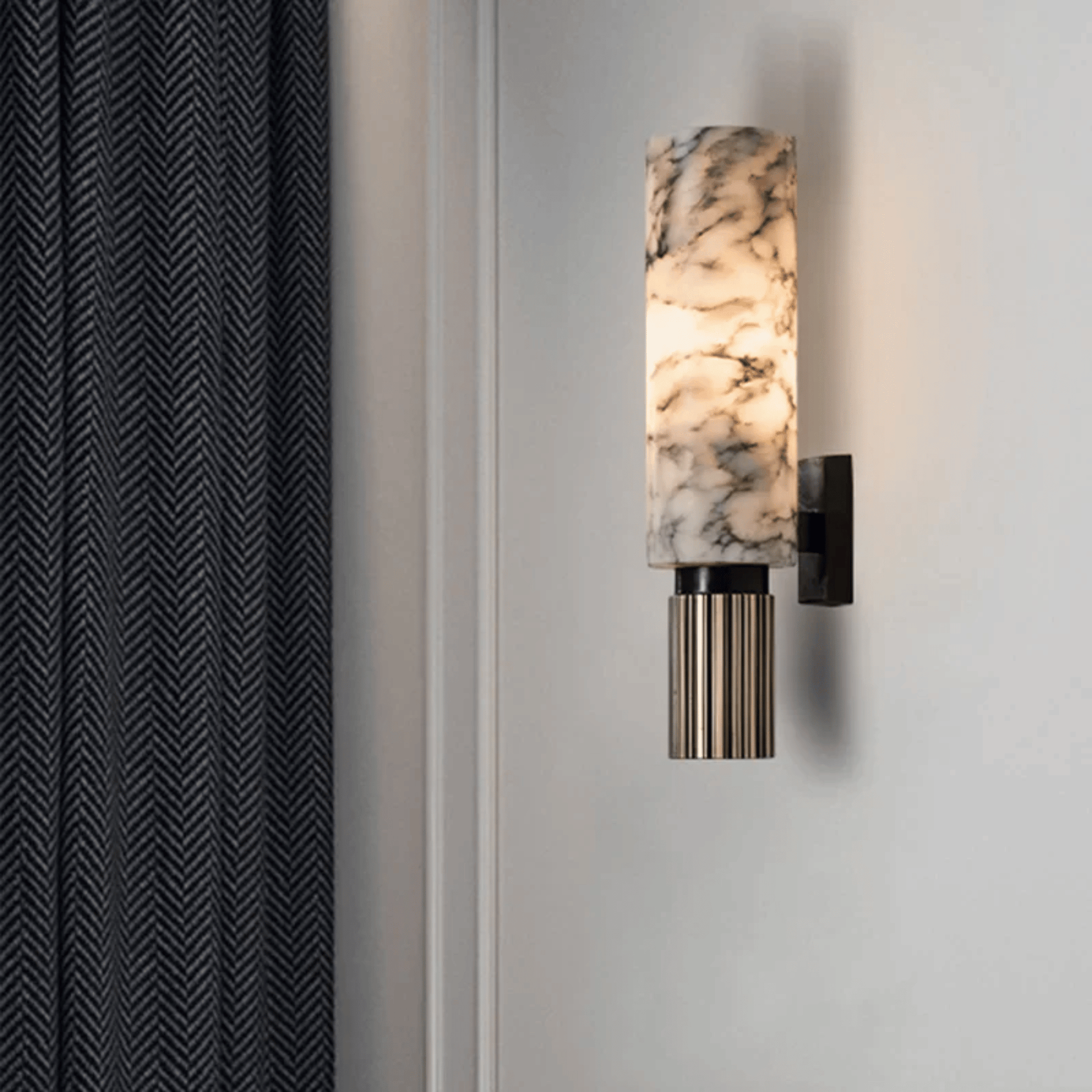Wall-mounted light fixture with marble-like design on a neutral wall.