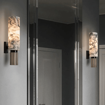Pair of wall sconces with marble-like finish on a gray wall.