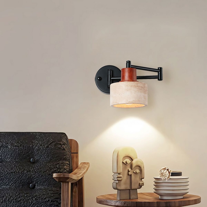 Wall-mounted lamp with a wooden base and decorative sculpture on a table.